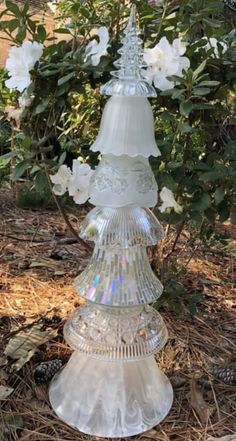 a glass tree with white flowers in the background