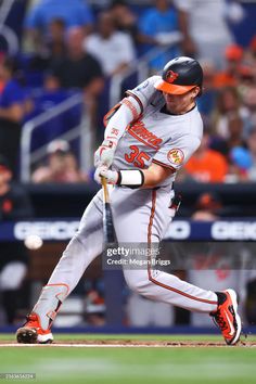 a baseball player swinging his bat at the ball in front of an oncoming crowd