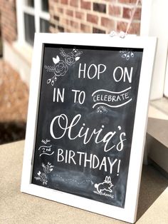 a chalkboard sign that says, hop on in to celebrate ollie's birthday