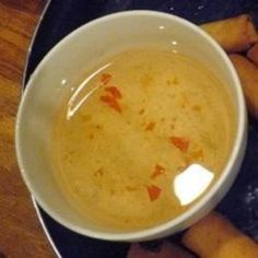 a white bowl filled with soup next to some carrots