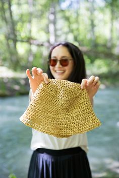 a woman holding up a straw hat in front of her face