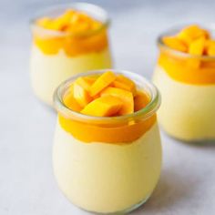 three small glasses filled with pudding and topped with mango slices