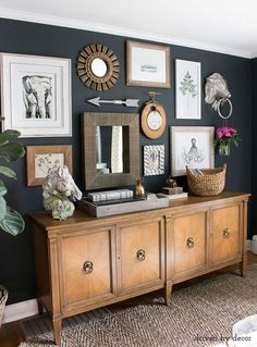 a living room with pictures on the wall and a wooden dresser in front of it