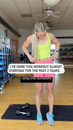 a woman standing on a yoga mat in a gym