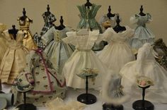 a table topped with lots of different types of dresses