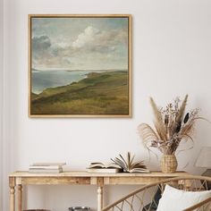 a painting hanging on the wall next to a table with books and plants in it