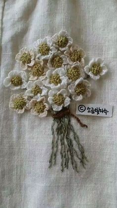 a bunch of flowers sitting on top of a white table cloth next to a tag