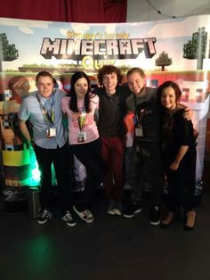 a group of people standing next to each other in front of a minecraft banner