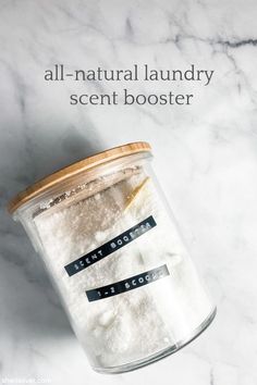 a glass jar filled with white powder on top of a marble counter next to the words all - natural laundry scent booster