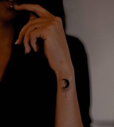 a woman with a small tattoo on her left arm and the moon behind her head