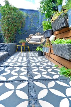 an outdoor patio with potted plants on the side and a bench in the middle