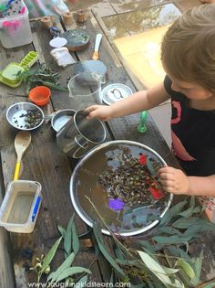 a young child is playing with some plants