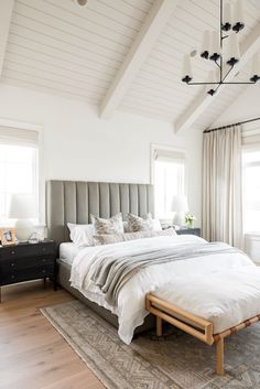 a bedroom with a bed, dresser and lamps in it's centerpieces