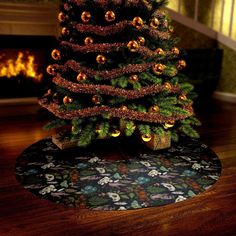 a small christmas tree on a rug in front of a fireplace