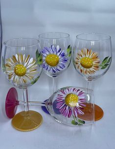 three wine glasses with painted flowers on them