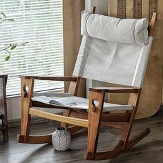 a rocking chair next to a window with blinds