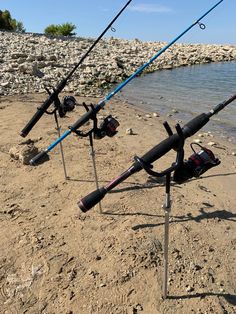 several fishing rods are on the beach near the water's edge, and there is no image here to provide a caption for