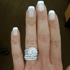 a woman's hand with two wedding rings on top of her finger, and the ring