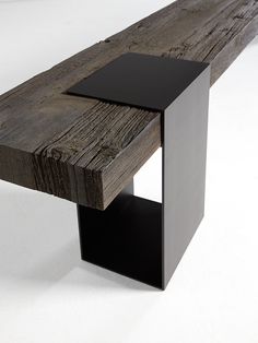 a wooden bench with black metal legs and an instagram button on the left side