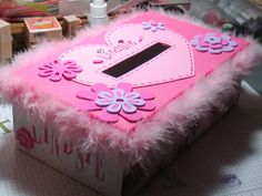 a pink box decorated with flowers and feathers