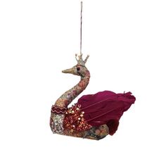 an ornament shaped like a peacock wearing a red dress and holding a string