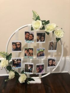 a white circular frame with photos and flowers on it, sitting on a wooden floor