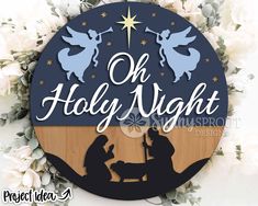 a nativity scene with the birth of jesus and baby jesus in silhouette on a wooden plaque