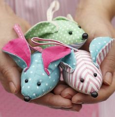 two small stuffed animals are held in hands