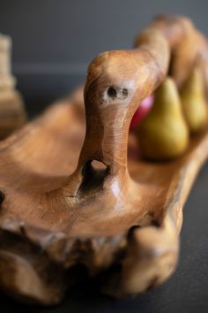 a wooden bowl with two pears in it