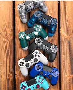 several video game controllers lined up on a wooden surface