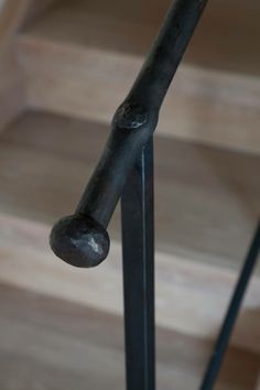 an iron handrail with wooden steps in the background