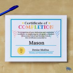 a certificate is placed on top of a desk with a pen and paper clipping