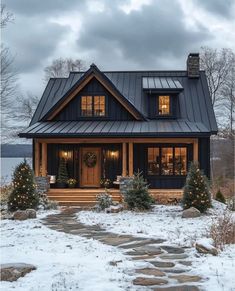 a house that has some lights on the front and side of it in the snow