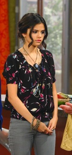 a woman standing in front of a table with food on it and wearing a necklace