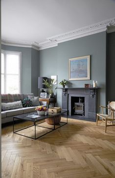 a living room filled with furniture and a fire place next to a wooden floored floor