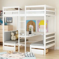 a white bunk bed sitting next to a desk with a stuffed animal on top of it