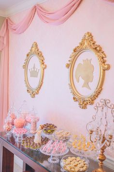 a table topped with lots of desserts next to a wall covered in pink curtains