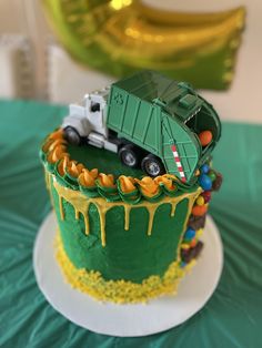 a green and yellow birthday cake with a truck on top