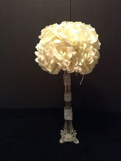 a glass vase filled with white flowers on top of a table