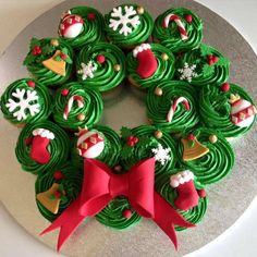 a christmas wreath cake with green frosting and decorated cupcakes in the middle