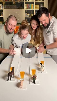 a group of people standing around a table