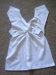 the back of a dress with a bow on it's side, laying on the floor