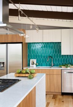 a kitchen with wooden cabinets and white counter tops, stainless steel appliances and an island