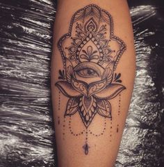 a woman's leg with an ornate tattoo design on the side of her thigh