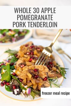 a white plate topped with meat covered in pomegranate next to a fork