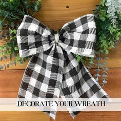 a black and white checkered bow with the words decorate your wreath above it on a wood background