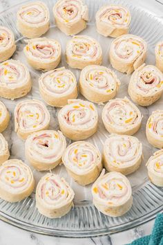 a glass platter filled with rolls on top of a marble counter