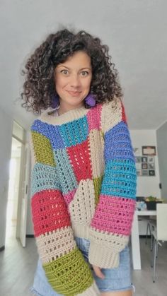 a woman wearing a multicolored crocheted sweater