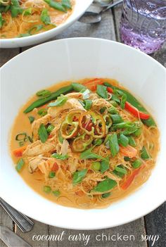 two white bowls filled with food on top of a wooden table