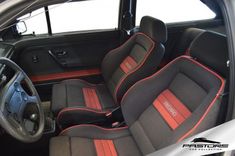 the interior of a car with black and red seats